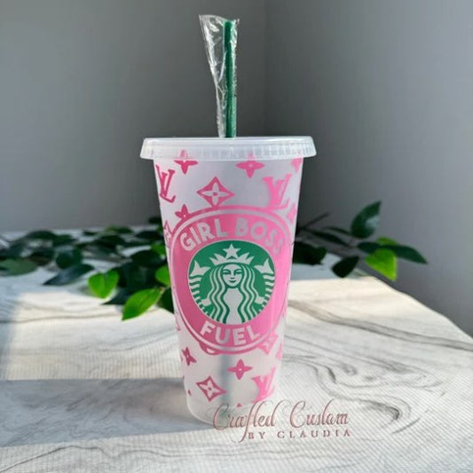 A personalized plastic reuseable cup with a pink design, white vinyl text saying 'GIRL BOSS FUEL', and a green straw.
