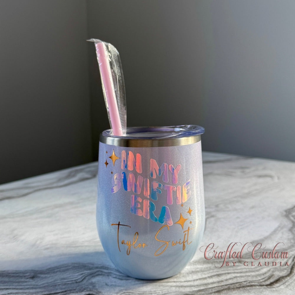 Lilac tumbler with colourful text βIn My Swiftie Eraβ and straw on a marble surface