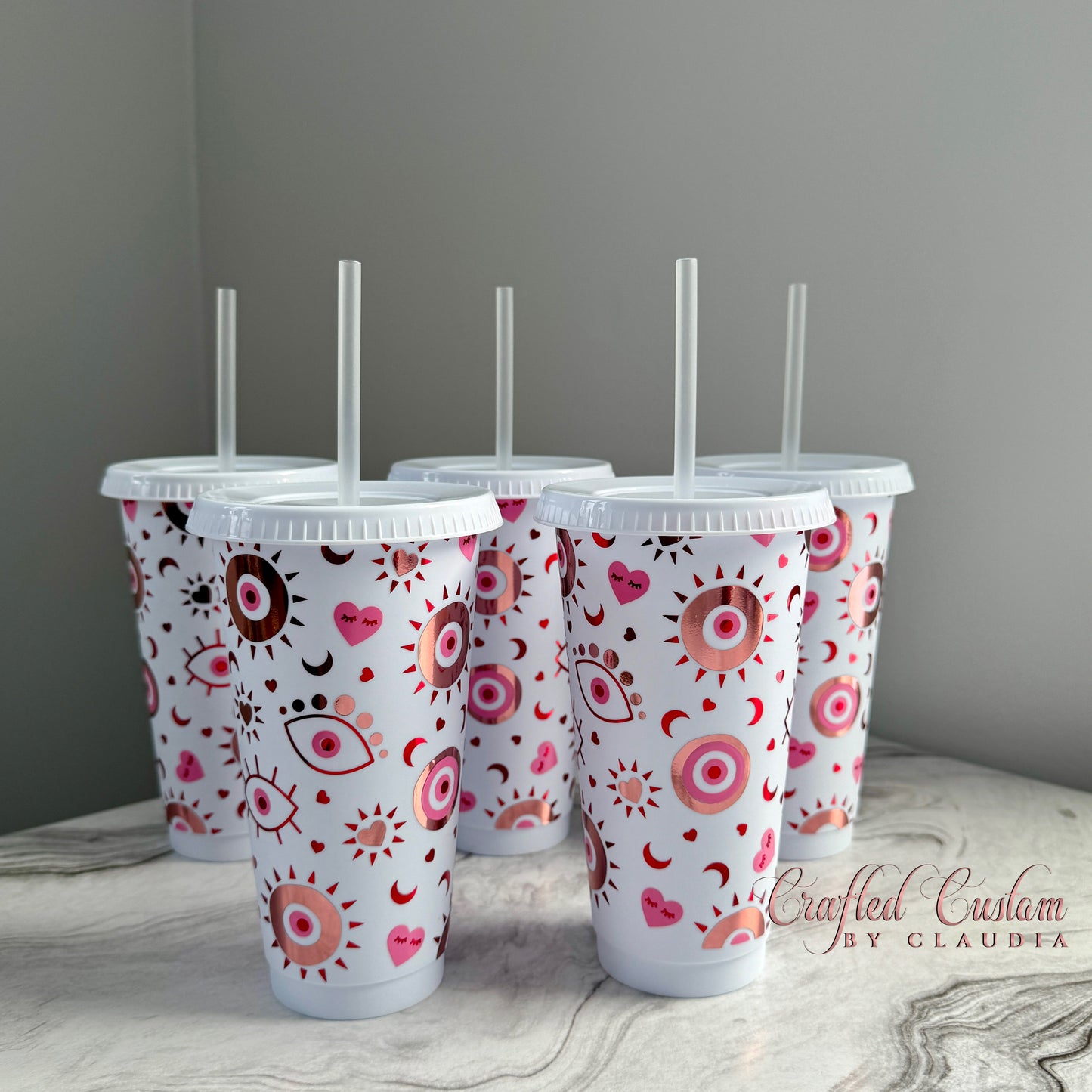 Valentine-themed cold tumbler with pink and red evil eye and heart pattern – reusable cup with straw, made by Crafted Custom by Claudia.