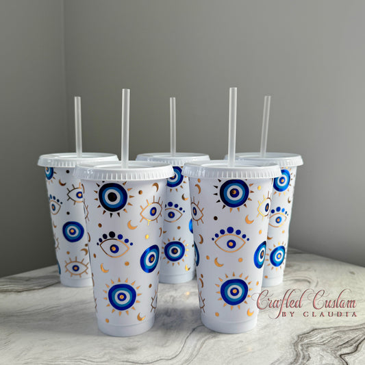 White reusable cold cup with blue and gold evil eye pattern – handmade tumbler with straw, created by Crafted Custom by Claudia.