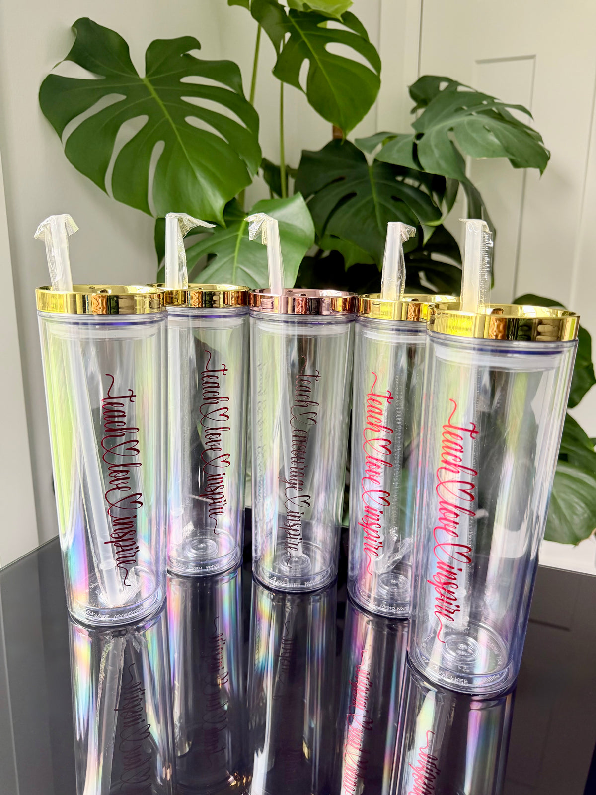 Four gold lid acrylic skinny tumblers - teach love inspire in red chrome vinyl. 

One rose gold lid skinny acrylic tumbler - teach encourage inspire in chrome rose gold vinyl 