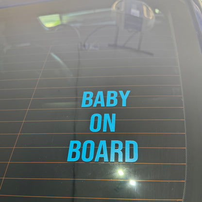 Blue 'BABY ON BOARD' decal on a car window