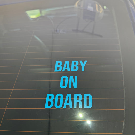 Blue 'BABY ON BOARD' decal on a car window